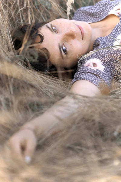 Girl lies in dry grass — Stock Photo, Image