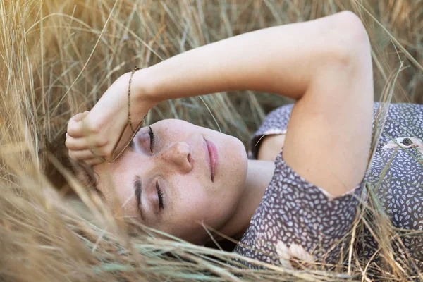 Fille se trouve dans l'herbe sèche — Photo