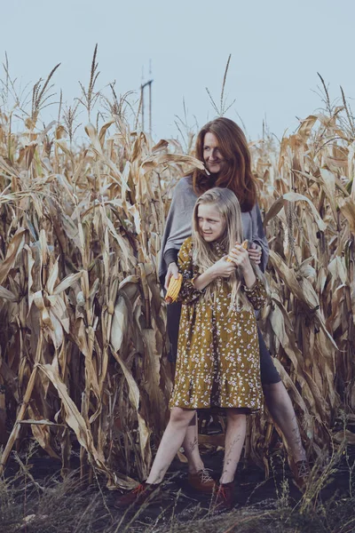 Mamá y su hija en un campo de maíz — Foto de Stock