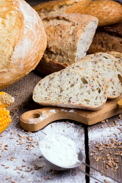 Frisches Brot und Weizen auf dem Holz — Stockfoto