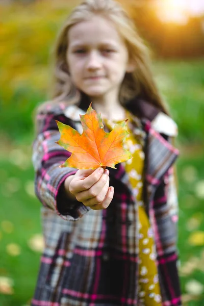 Menina detém uma folha vermelha — Fotografia de Stock