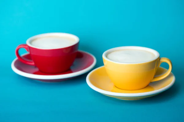 Tasse jaune et rouge sur fond bleu — Photo