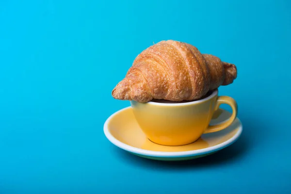 Gelbe Tasse auf blauem Hintergrund — Stockfoto