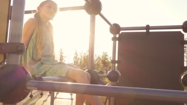 Niña Sentada Patio Recreo Mañana Balanceando Las Piernas Los Rayos — Vídeos de Stock