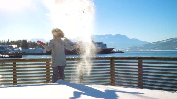 Feliz Chica Sonriente Lanzando Nieve Una Orilla Del Océano Con — Vídeo de stock