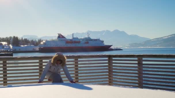 Happy Smiling Girl Throwing Snow Ocean Shore View Cruise Ship — стоковое видео