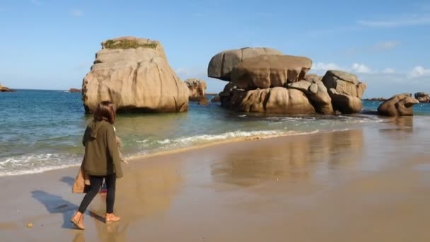 フランス北部の大西洋のブレトン海岸の空の砂浜を歩く母と娘 — ストック動画