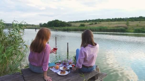 Zwei Mädchen Genießen Ein Picknick Auf Einem Hölzernen Steg Einem — Stockvideo