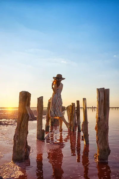 有名なピンク色の塩の湖で日没時にポーズをとる女の子 — ストック写真