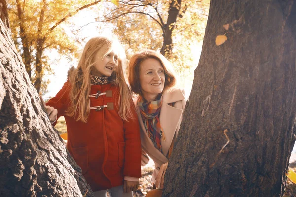 幸せな家族だ 秋の公園で笑顔のお母さんと娘さん — ストック写真