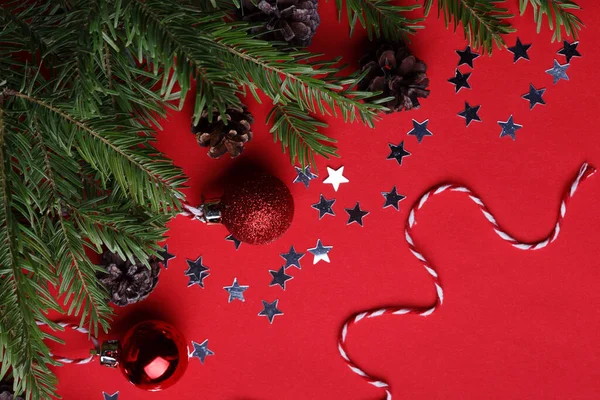 Een Kerstachtergrond Kerst Boom Twijgen Kerst Ballen Kegels Een Rode — Stockfoto