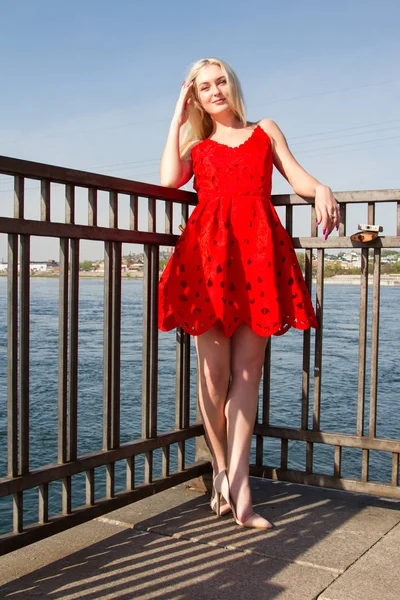Kırmızı Elbiseli Kız Nehir Dolgu Üzerinde Duruyor — Stok fotoğraf
