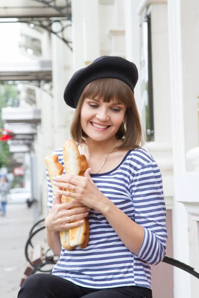 Genç kız bir bankta oturur ve bir rulo tutar