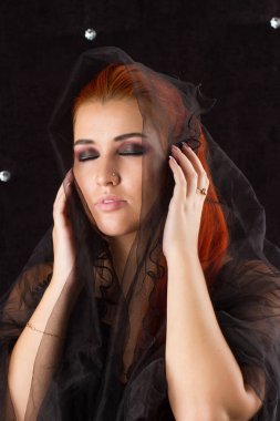 Siyah bir örtü ile Kızıl saçlı kız