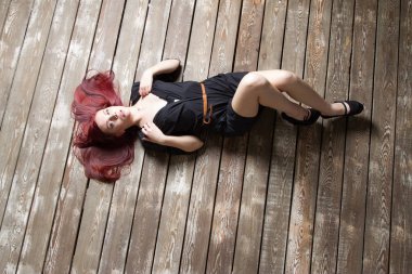 Kızıl saçlı kız yerde yatarken