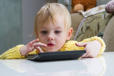 küçük çocuk heyecanla hesap makinesinde sayar