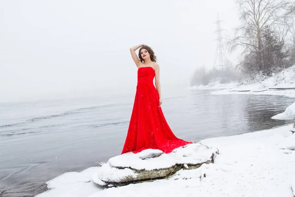 Młoda Dziewczyna Czerwonej Sukience Wieczorem Nad Brzegiem Rzeki Śniegu — Zdjęcie stockowe