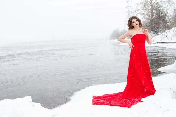 Jovem Vestido Vermelho Está Margem Rio Coberto Neve — Fotografia de Stock