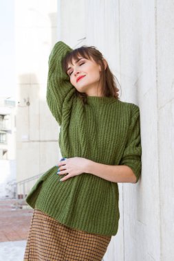 genç kız sokakta, duvara yaslanmış duran