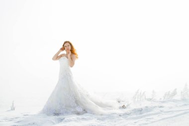 Kış sis arka plan üzerinde kırmızı saçlı gelin