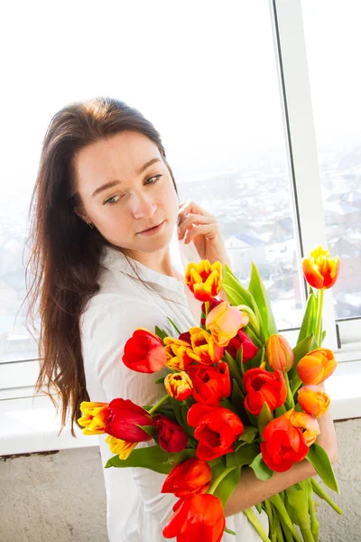 Bir buket lale taşıyan kız.