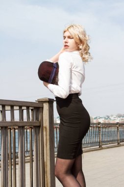 Güneşli bir günde nehrin arka planında şapkalı sarışın