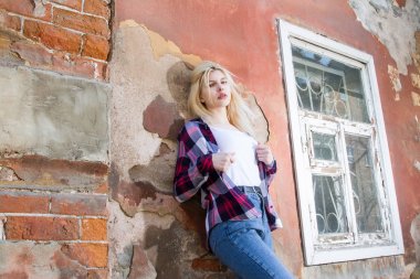 Harap bir evin duvarında duran sarışın