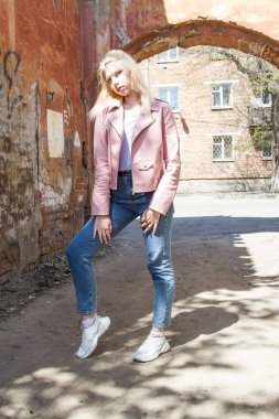 Eski harap evin kemer arka planda pembe deri ceket ve kot Blonde