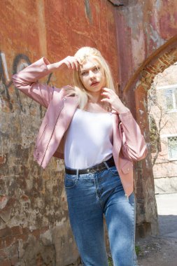 Eski harap evin kemer arka planda pembe deri ceket ve kot Blonde