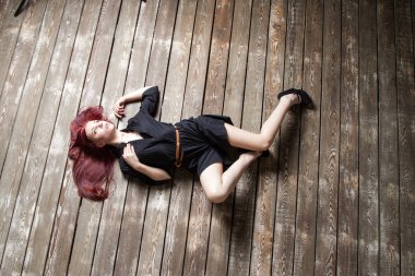 Genç kızıl saçlı kız yerde yatıyordu. Yukarıdan görüntüle