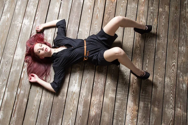 Genç kızıl saçlı kız yerde yatıyordu. Yukarıdan görüntüle