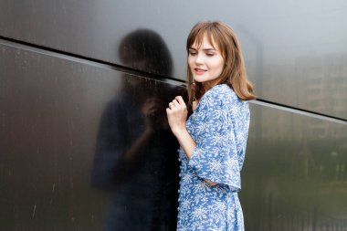 yüzünde çiller ile kız karanlık duvara karşı duruyor