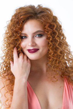 Parlak makyajlı kırmızı saçlı genç bir kızın portresi. Beyaz arka plan üzerine stüdyo portresi.