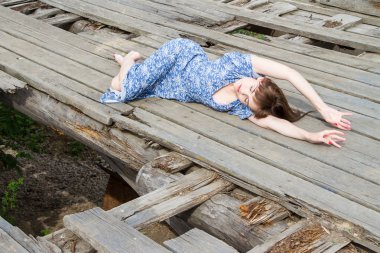 kız eski ahşap iskelede yatıyor