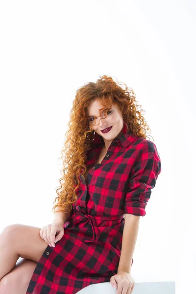 キューブに座っている感情的な赤毛の女の子 白い背景にスタジオの肖像画 — ストック写真