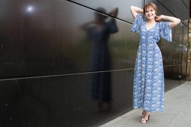 Siyah bir duvara karşı bir gece elbiseli Genç bir kızın portresi