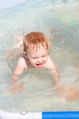 Havuzda yüzen neşeli çocuk