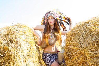 saman balyaları arasında Hintli bir savaşçı gibi giyinmiş kız