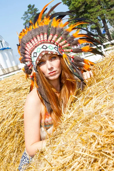 红头发的女孩打扮成印度战士的一叠稻草 — 图库照片