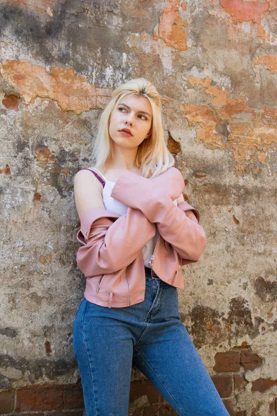 Beautiful Blonde Pink Jacket Stands Dilapidated Wall Sprinkling Plaster — Stock Photo, Image