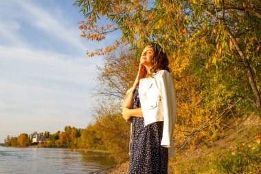 Angara kıyısında poz veren genç kız. Sonbahar portresi.