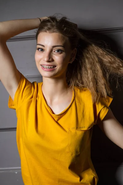 Młoda Dziewczyna Jasnożółtej Koszulce Stoi Ciemnym Pokoju Pod Ścianą — Zdjęcie stockowe