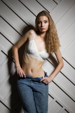 Sütyen ve kot pantolonlu seksi genç kız. Stüdyo resmi.
