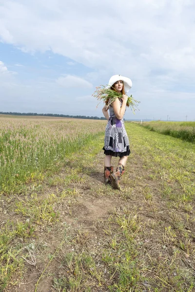 野花の間の野原の若い赤髪の少女 — ストック写真