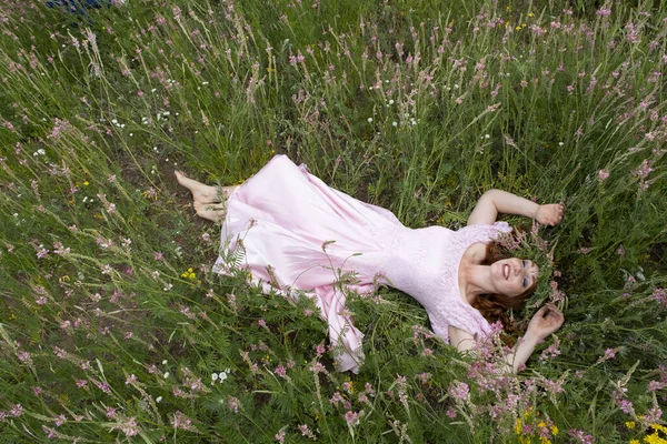 Dívka Dlouhých Růžových Šatech Leží Poli Mezi Kvetoucí Alfalfa — Stock fotografie