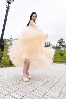 Uzun gece elbisesi giymiş ince bir genç kız.