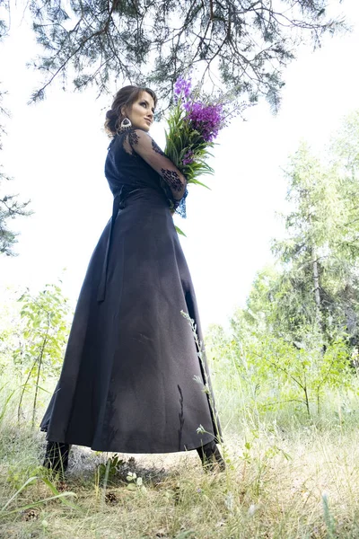 Menina Vestido Preto Longo Floresta Com Buquê Flores Silvestres — Fotografia de Stock