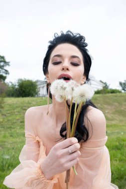 Elinde bir buket karahindiba olan genç kız.