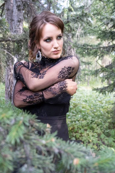 Fiatal Lány Egy Fekete Ruhában Háttérben Sűrű Erdő — Stock Fotó