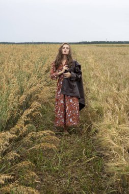 Genç kız tarlada olgunlaşmış arpa kulaklarının arasında